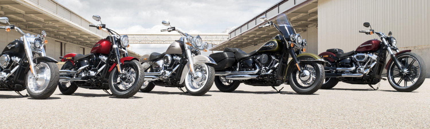 A lineup of Harley-Davidson® Street Bob® motorcycles that are parked between two warehouse buildings